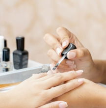 a woman is doing a manicure on a child's hand